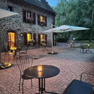 un patio con mesas y sombrillas frente a un edificio en Camping De La Sarre, en Abreschviller