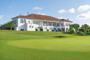 a house on a golf course with a green at Palácio Estoril Hotel, Golf & Wellness in Cascais
