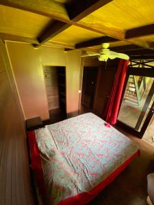 1 dormitorio con 1 cama en una habitación con ventana en Chalet Mahina, en Mahina