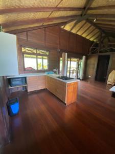 Großes Zimmer mit einer Küche und Holzböden. in der Unterkunft Chalet Mahina in Mahina