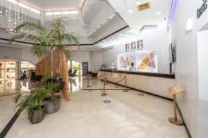 a lobby with a palm tree in a building at BM Beach Resort in Ras al Khaimah