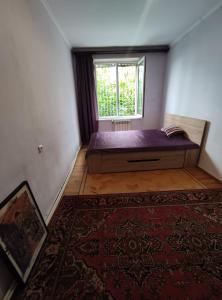 um quarto com uma cama, uma janela e um tapete em 1 Bedroom Cosy Apartment near Botanical Garden em Yerevan