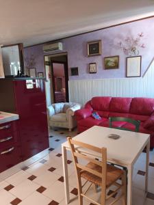 un soggiorno con divano rosso e tavolo di casa Anna a Vetralla