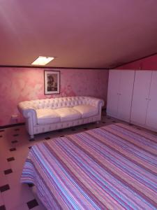 una camera rosa con letto bianco di casa Anna a Vetralla