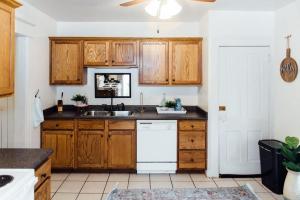 a kitchen with wooden cabinets and a white dishwasher at Campus Downtown WiFi Near Starbucks Superhosts in Ames