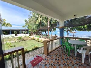 a balcony with a table and chairs and the ocean at Island Front - Bangcogon Resort and Restaurant in Oslob