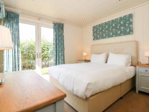 una camera con un grande letto e una grande finestra di Langham a Cottesmore