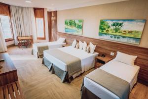 アララクアラにあるHotel Fazenda Salto Grandeのベッド2台とテーブルが備わるホテルルームです。