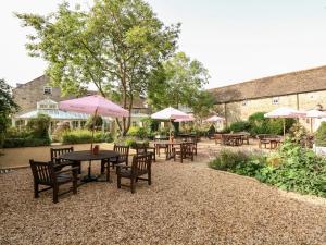 a patio with tables and chairs with umbrellas at Seaton in Cottesmore
