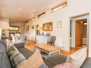 ein Wohnzimmer mit einem Sofa und einem Tisch in der Unterkunft Hambleton in Cottesmore