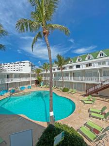 una piscina con una palmera frente a un hotel en Decameron Los Delfines - All Inclusive, en San Andrés