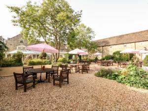 a patio with tables and chairs with umbrellas at Hambleton in Cottesmore
