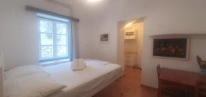 - une chambre avec un lit blanc et une fenêtre dans l'établissement Little Troll House 1, à Chrissi Akti
