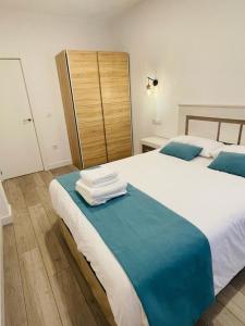 Un dormitorio con dos camas con toallas en la cama. en Apartamentos Rurales La Plaza 3, en Duruelo de la Sierra
