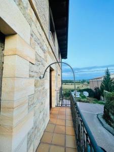 un edificio con un balcón con una puerta. en Apartamentos Rurales La Plaza 3, en Duruelo de la Sierra
