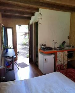 Habitación con cocina, cama y mesa. en Cabañas Isla Neruda, en El Quisco
