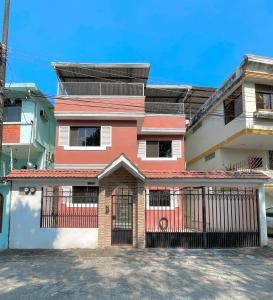 uma casa vermelha e branca com um portão em Casa con Habitación Privada em Guayaquil