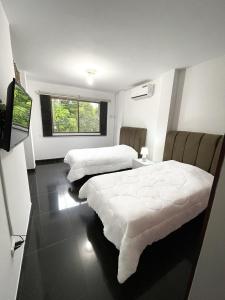um quarto com duas camas e uma televisão em Casa con Habitación Privada em Guayaquil