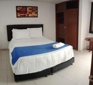 a bedroom with a large bed with a blue blanket at Hotel AG Boutique in Bogotá