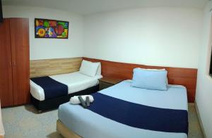 a hotel room with two beds and a chair at Hotel AG Boutique in Bogotá