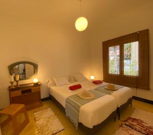 1 dormitorio con cama, espejo y ventana en La Casita a 60 pasos del mar en Tamaduste