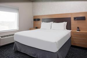 a large white bed in a room with a window at TownePlace Suites by Marriott Orlando Airport in Orlando