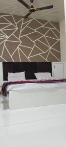 1 dormitorio con 1 cama y ventilador de techo en Hotel shree Gajanand palace, en Ujjain
