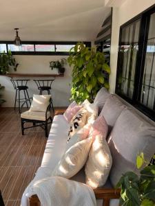 ein Wohnzimmer mit einer Couch mit Kissen darauf in der Unterkunft Casa Privado- 2 Bedroom House Near the Airport in Puerto Princesa