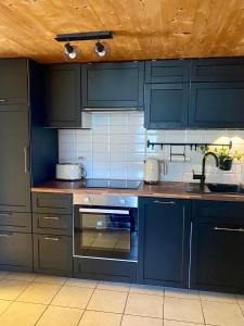a kitchen with navy blue cabinets and a stove at Ferienwohnung in Stein AR in Stein