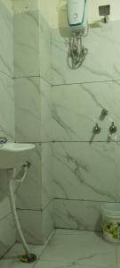 baño con lavabo y paredes de mármol blanco en Hotel shree Gajanand palace, en Ujjain