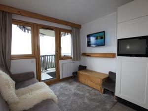 a living room with a flat screen tv and a chair at Charmant studio cabine avec WiFi à Avoriaz - FR-1-314-159 in Morzine