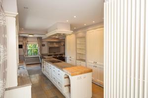 a kitchen with white cabinets and a kitchen island at De Boter Villa in Diksmuide