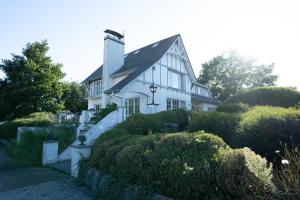 ein weißes Haus mit schwarzem Dach und einigen Büschen in der Unterkunft De Boter Villa in Diksmuide