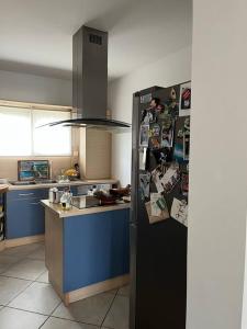 una cucina con un frigorifero pieno di magneti di Maison 160m2 Eysines a Eysines Altre 2 foto