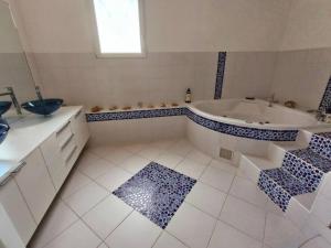 ein Badezimmer mit einer Badewanne, einem Waschbecken und einer Badewanne in der Unterkunft Maison 160m2 Eysines in Eysines