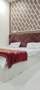 Una cama con una manta roja encima. en Hotel shree Gajanand palace, en Ujjain