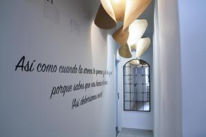 a hallway with a chandelier and a sign on the wall at NATURA ROOMS 