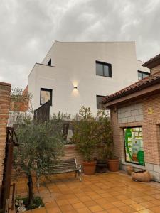 a white house with a bench in front of it at NATURA ROOMS in Alalpardo