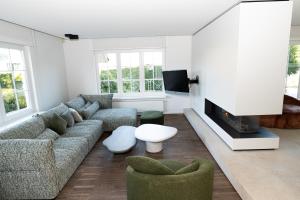ein Wohnzimmer mit einem Sofa und einem Kamin in der Unterkunft De Boter Villa in Diksmuide
