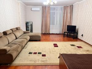 sala de estar con sofá y TV en Апартаменты с 2 спальнями, en Atyraū