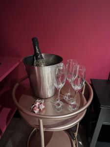 un secchio di vino su un tavolo con bicchieri da vino di The Indulging Basement a Barnsley