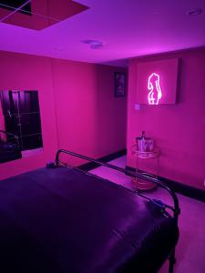 ein Schlafzimmer mit einem Bett in einem rosa Zimmer in der Unterkunft The Indulging Basement in Barnsley