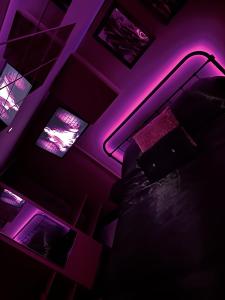 a bedroom with a bed with a purple lighting at The Indulging Basement in Barnsley