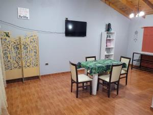 a dining room with a table and chairs and a television at Amplio departamento para 2 personas in Neuquén