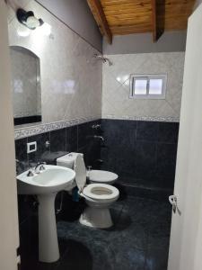 a bathroom with a white toilet and a sink at Amplio departamento para 2 personas in Neuquén