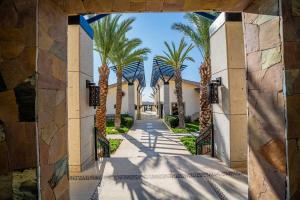 a hallway with palm trees in front of a building at Casa Paradiso Copala Private Home in Quivira Community in Cabo San Lucas