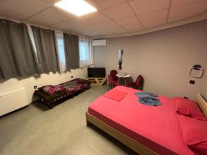 una camera con letto rosso e un soggiorno di Debbies rooms 8 a Salonicco
