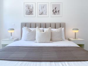 1 dormitorio con 1 cama grande con almohadas blancas en Phaedrus Living White Hills Suites Panoramic View, en Aglantzia