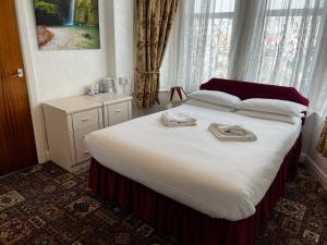 a bedroom with a large bed with two towels on it at Delton Hotel in Blackpool