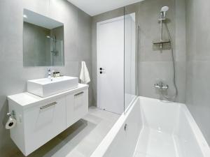 a white bathroom with a sink and a shower at Phaedrus Living White Hills Suites Panoramic View in Aglantzia